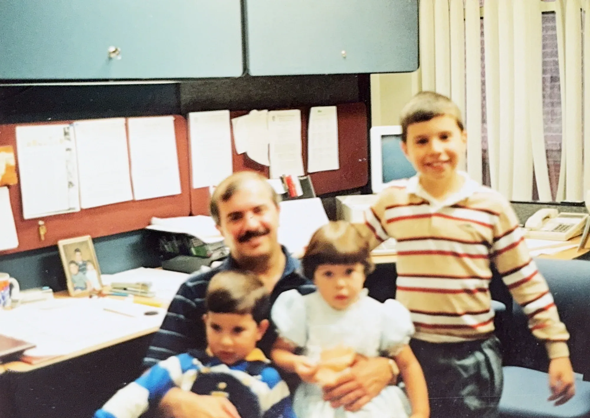 Bert at his office desk with his three children Danny, Anthony, and Laura, early 1990s